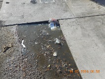 Polluted pool of wash water cigarettes and trash